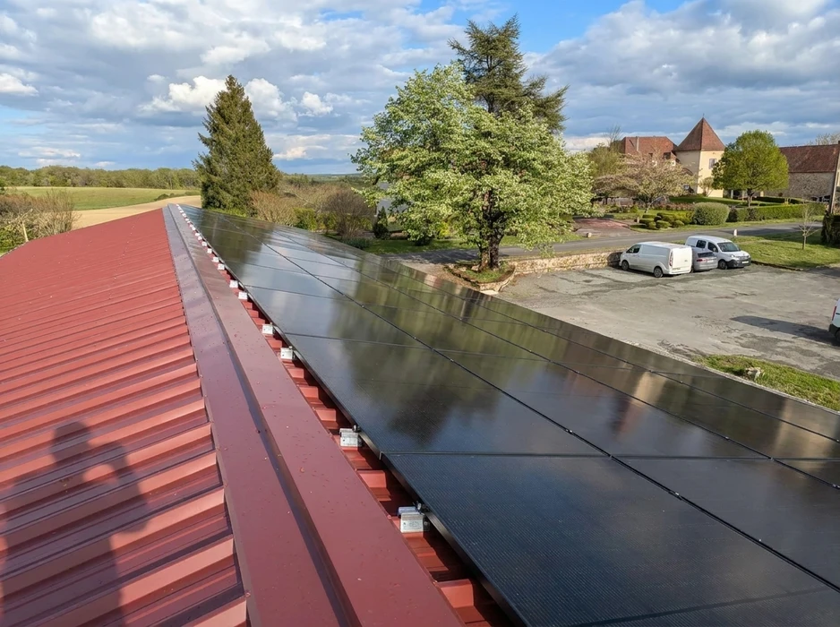 Installation de panneaux solaires photovoltaïques full black sur toiture métallique à bac acier rouge