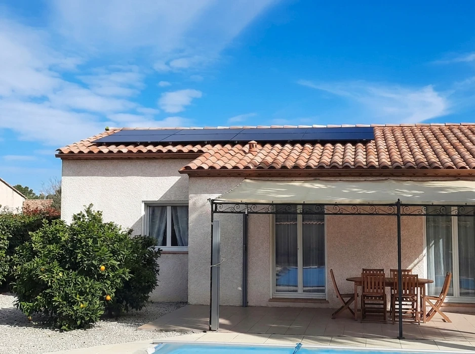 Toiture en tuiles canal orangées avec installation de panneaux solaires photovoltaïques monocristallins noirs